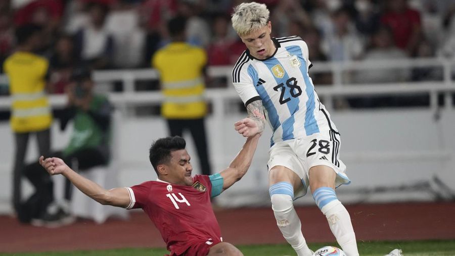 Alejandro Garnacho Ferreyra dari Argentina, kanan, bertarung memperebutkan bola melawan pemain Indonesia Asnawi Mangkualam dalam pertandingan sepak bola persahabatan mereka di Stadion Utama Gelora Bung Karno di Jakarta, Indonesia, Senin, 19 Juni 2023. (AP Photo/Tatan Syuflana)