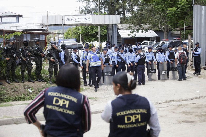 Penjaga penjara menjaga narapidana di penjara Pusat Wanita untuk Adaptasi Sosial (CEFAS) setelah kebakaran menyusul perkelahian antar narapidana di Tamara, sekitar 25 km dari Tegucigalpa, Honduras pada 20 Juni 2023. Bentrokan antara geng saingan di penjara wanita di Honduras tersisa di Sedikitnya 41 orang tewas pada Selasa, kata polisi kepada AFP. Kekerasan itu terjadi di sebuah penjara sekitar 25 kilometer (sekitar 15 mil) utara ibu kota Tegucigalpa, menurut juru bicara polisi Edgardo Barahona, yang menyebut jumlah 