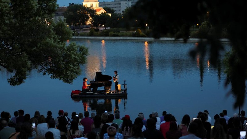 Pianis asal Prancis Violette Prevost menghibur ratusan warga di danau Pradolongo, Usera, Madrid, Spanyol. (REUTERS/Isabel Infantes)