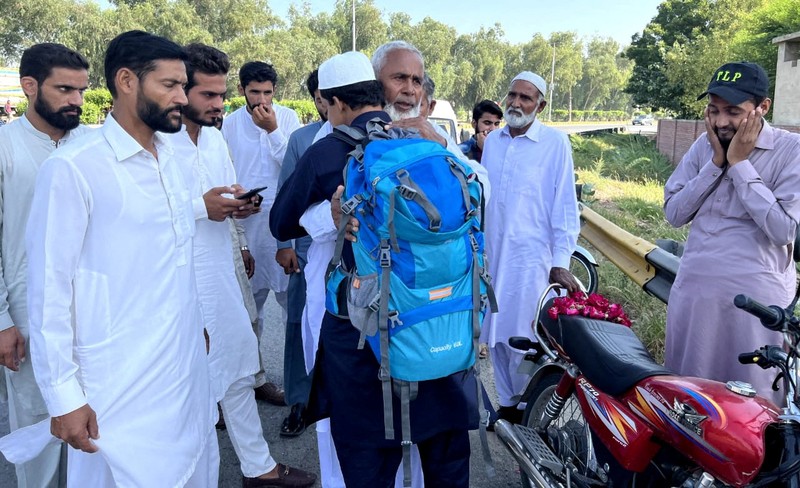 A Pakistani student, Usman Arshad, who walked 5400km from his home town, Okra, Pakistan to Mecca, Saudi Arabia to perform Haj, greets his family before heading out on his journey from Okra, Pakistan, in this handout photo obtained by Reuters on June 23, 2023. Usman Arshad/Handout via REUTERS ATTENTION EDITORS - THIS PICTURE WAS PROVIDED BY A THIRD PARTY