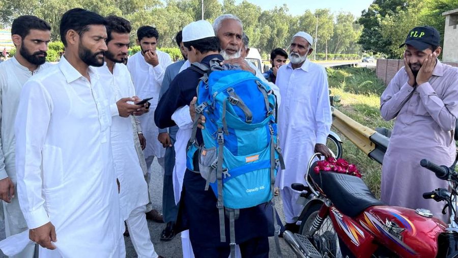 A Pakistani student, Usman Arshad, who walked 5400km from his home town, Okra, Pakistan to Mecca, Saudi Arabia to perform Haj, greets his family before heading out on his journey from Okra, Pakistan, in this handout photo obtained by Reuters on June 23, 2023. Usman Arshad/Handout via REUTERS ATTENTION EDITORS - THIS PICTURE WAS PROVIDED BY A THIRD PARTY