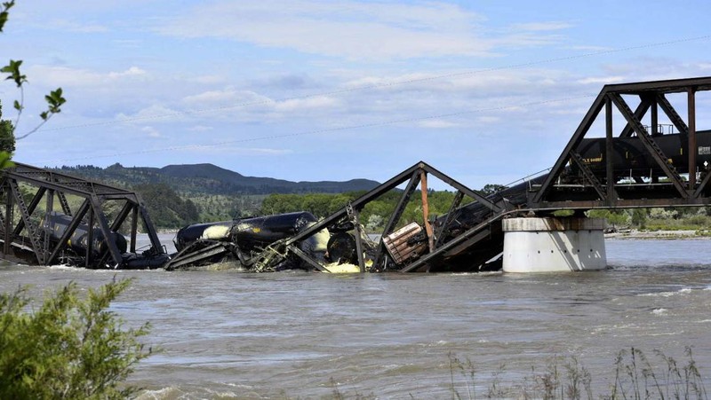 Kereta api terguling di negara bagian Montana, Amerika Serikat (AS), dan menyebabkan jembatan di atas Sungai Yellowstone runtuh pada Sabtu pagi, (24/6/2023) waktu setempat. (AP/Larry Mayer)