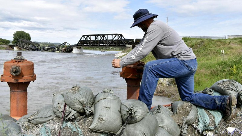 Kereta api terguling di negara bagian Montana, Amerika Serikat (AS), dan menyebabkan jembatan di atas Sungai Yellowstone runtuh pada Sabtu pagi, (24/6/2023) waktu setempat. (AP/Larry Mayer)