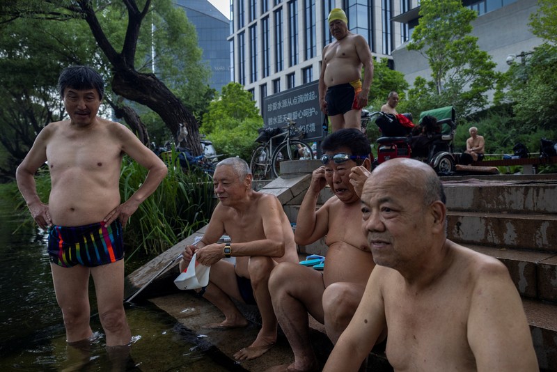 Anak-anak mendinginkan diri dengan kipas angin listrik saat beristirahat. (AP/Andy Wong)