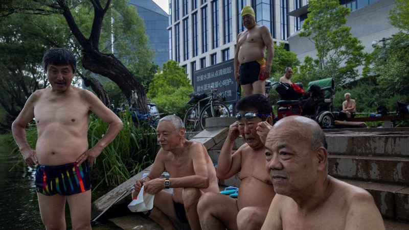 Anak-anak mendinginkan diri dengan kipas angin listrik saat beristirahat. (AP/Andy Wong)