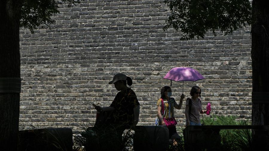 Anak-anak mendinginkan diri dengan kipas angin listrik saat beristirahat. (AP/Andy Wong)