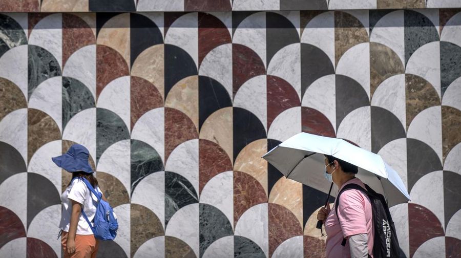 Anak-anak mendinginkan diri dengan kipas angin listrik saat beristirahat. (AP/Andy Wong)
