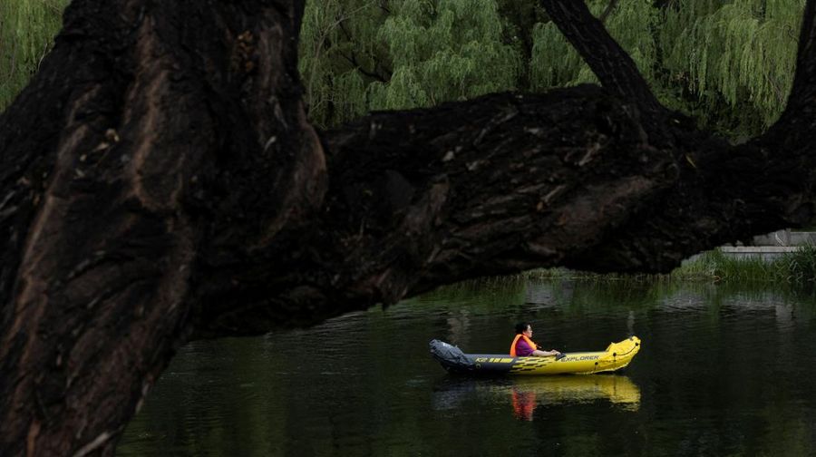 Anak-anak mendinginkan diri dengan kipas angin listrik saat beristirahat. (AP/Andy Wong)