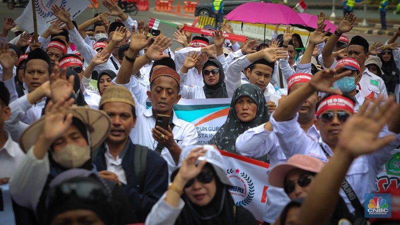 Massa aksi guru Madrasah yang tergabung dalam Forum Guru Sertifikasi Non Inpassing (FGSNI) melakukan unjuk rasa di kawasan Patung Kuda, Monas, Jakarta, Senin (26/6/2023). (CNBC Indonesia/Faisal Rahman)