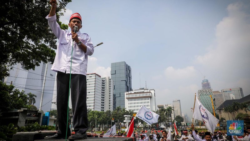 Massa aksi guru Madrasah yang tergabung dalam Forum Guru Sertifikasi Non Inpassing (FGSNI) melakukan unjuk rasa di kawasan Patung Kuda, Monas, Jakarta, Senin (26/6/2023). (CNBC Indonesia/Faisal Rahman)