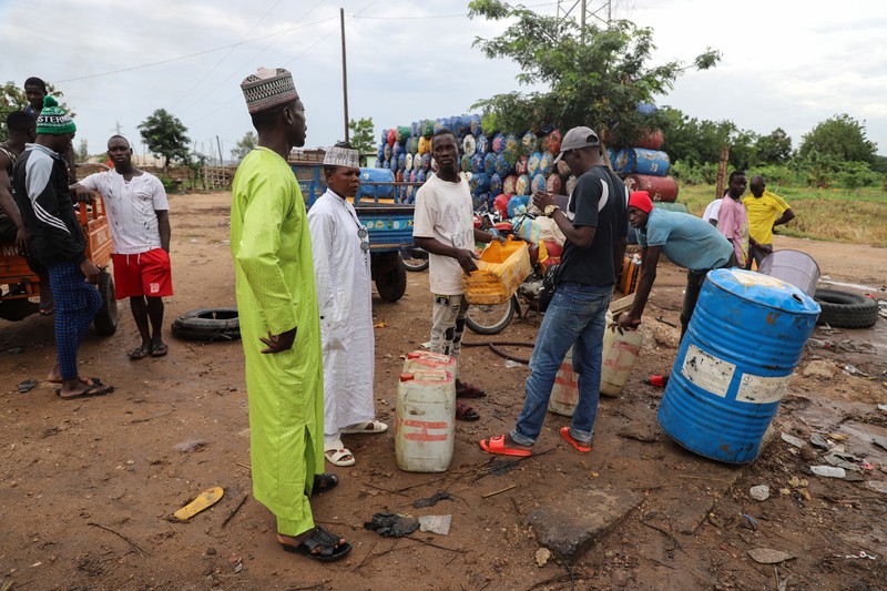 NIGERIA-PETROL/NEIGHBOURS A cameroon customs officer sits on a motorcycle taxi that's getting refuelled with smuggled Nigerian fuel in Garoua, Cameroon June 21, 2023. REUTERS/Desire Danga Essigue