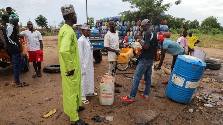 Yaouba Ahmadou, in white dress, a semi-wholesaler of Nigeria's contraband fuel speaks with his workers in Garoua, Cameroon June 21, 2023. REUTERS/Desire Danga Essigue