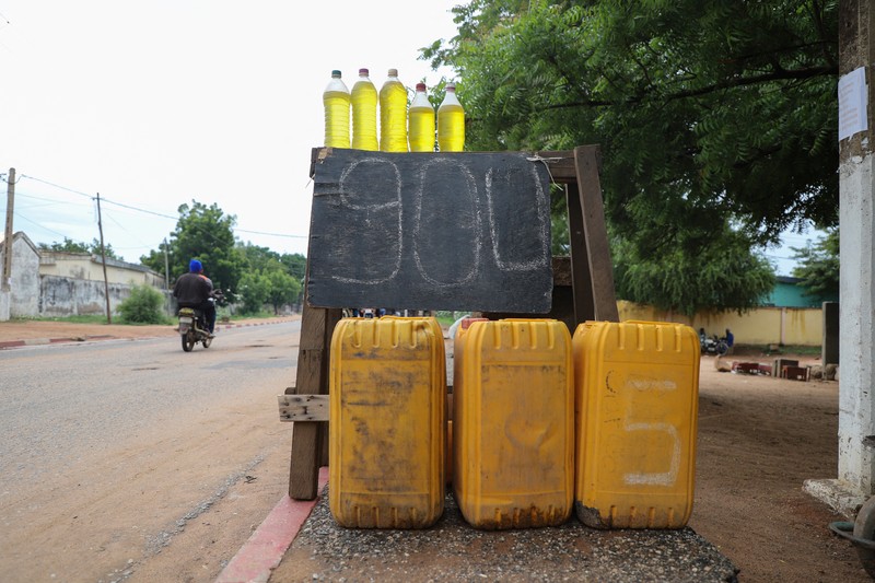 NIGERIA-PETROL/NEIGHBOURS A cameroon customs officer sits on a motorcycle taxi that's getting refuelled with smuggled Nigerian fuel in Garoua, Cameroon June 21, 2023. REUTERS/Desire Danga Essigue