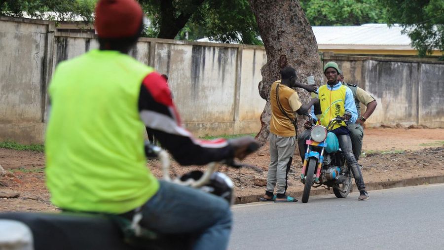 A cameroon customs officer sits on a motorcycle taxi that's getting refuelled with smuggled Nigerian fuel in Garoua, Cameroon June 21, 2023. REUTERS/Desire Danga Essigue