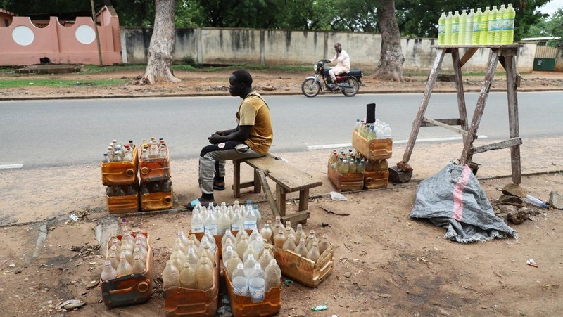 A cameroon customs officer sits on a motorcycle taxi that's getting refuelled with smuggled Nigerian fuel in Garoua, Cameroon June 21, 2023. REUTERS/Desire Danga Essigue