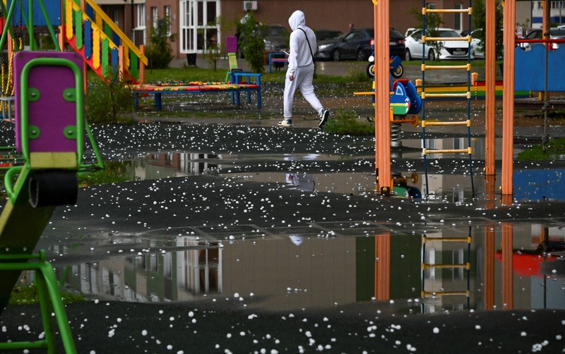 Seorang penduduk setempat memperagakan hujan es setelah badai es di kota Siberia, Omsk, Rusia, 27 Juni 2023. Seorang penduduk setempat memperagakan hujan es setelah badai es di kota Siberia, Omsk, Rusia, 27 Juni 2023. (REUTERS/Alexey Malgavko)