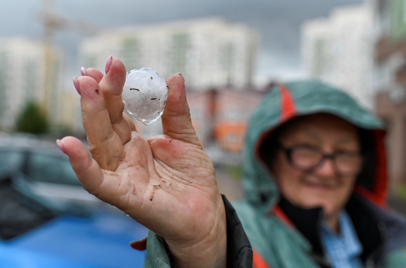 Seorang penduduk setempat memperagakan hujan es setelah badai es di kota Siberia, Omsk, Rusia, 27 Juni 2023. Seorang penduduk setempat memperagakan hujan es setelah badai es di kota Siberia, Omsk, Rusia, 27 Juni 2023. (REUTERS/Alexey Malgavko)