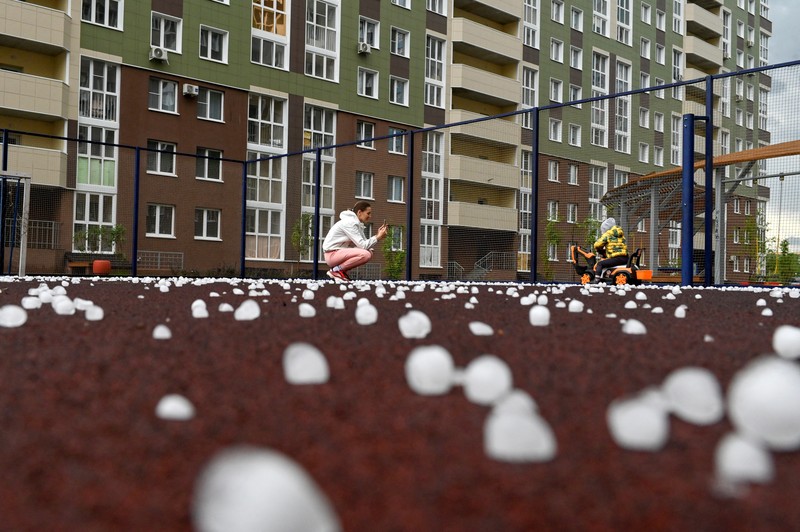 Seorang penduduk setempat memperagakan hujan es setelah badai es di kota Siberia, Omsk, Rusia, 27 Juni 2023. Seorang penduduk setempat memperagakan hujan es setelah badai es di kota Siberia, Omsk, Rusia, 27 Juni 2023. (REUTERS/Alexey Malgavko)