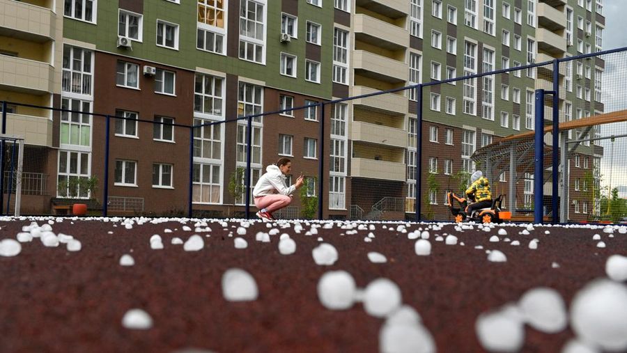 Seorang penduduk setempat memperagakan hujan es setelah badai es di kota Siberia, Omsk, Rusia, 27 Juni 2023. (REUTERS/Alexey Malgavko)