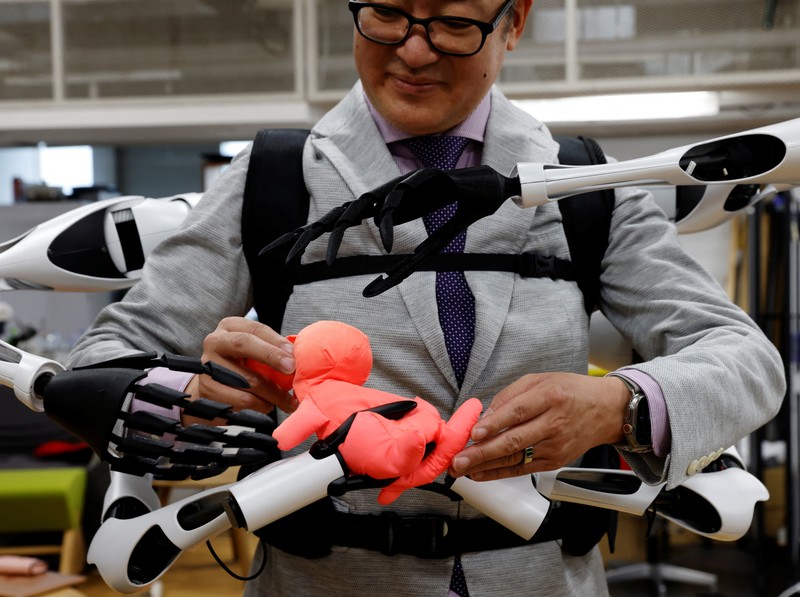 Masahiko Inami dari University of Tokyo berpose dengan lengan robot 