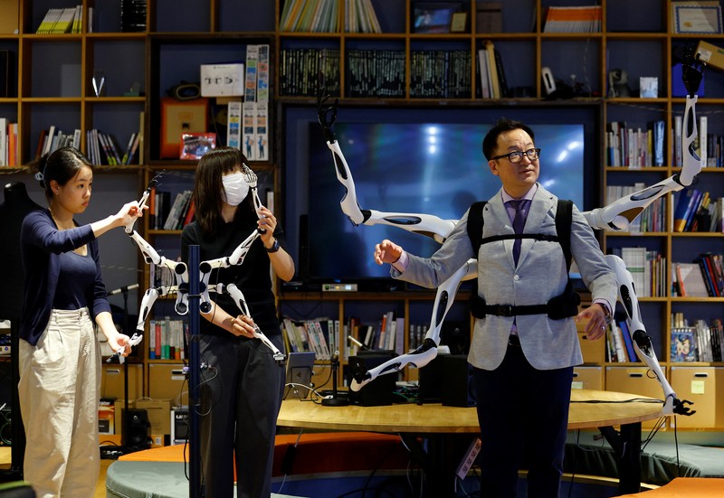 Masahiko Inami dari University of Tokyo berpose dengan lengan robot 