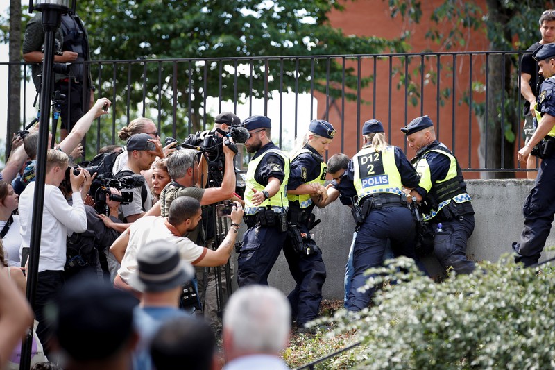Seorang demonstran membakar Alquran di luar masjid pusat Stockholm di Stockholm, Swedia 28 Juni 2023. (TT News Agency/Stefan Jerrevang/via REUTERS)