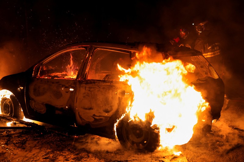 A French firefighter works to extinguish a burning car during Kerusuhan akibat seorang remaja ditembak mati oleh Polisi di pinggiran kota Paris, Prancis, Minggu (2/7/2023). A French firefighter works to extinguish a burning car during Kerusuhan akibat seorang remaja ditembak mati oleh Polisi di pinggiran kota Paris, Prancis, Minggu (2/7/2023).
(REUTERS/Pascal Rossignol)