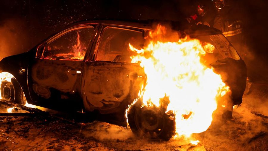 A French firefighter works to extinguish a burning car during Kerusuhan akibat seorang remaja ditembak mati oleh Polisi di pinggiran kota Paris, Prancis, Minggu (2/7/2023).
(REUTERS/Pascal Rossignol)