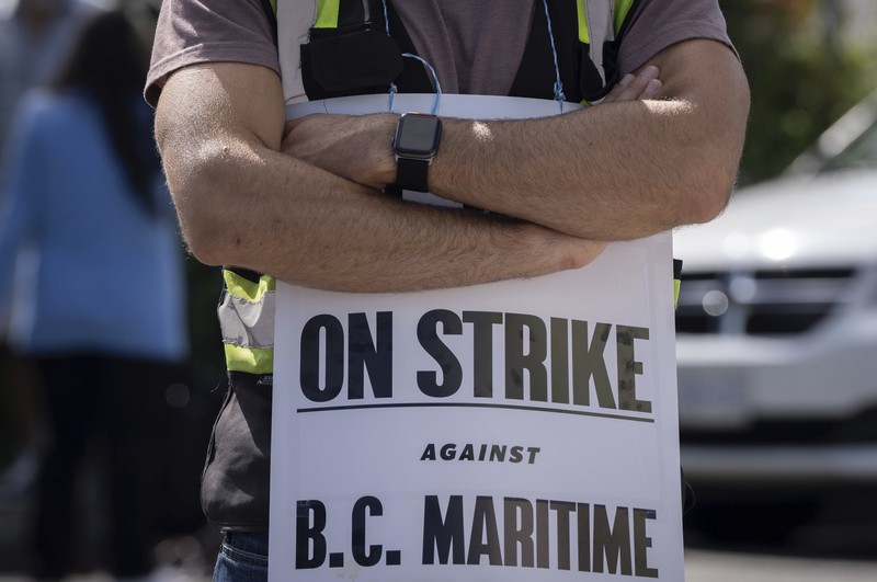 Canada Vancouver Port Strike International Longshore and Warehouse Union workers picket outside of the BC Maritime Employers Association Dispatch Center after a 72 hour strike notice and no agreement made on the bargaining table in Vancouver, on Saturday, July 1, 2023. (Ethan Cairns /The Canadian Press via AP)