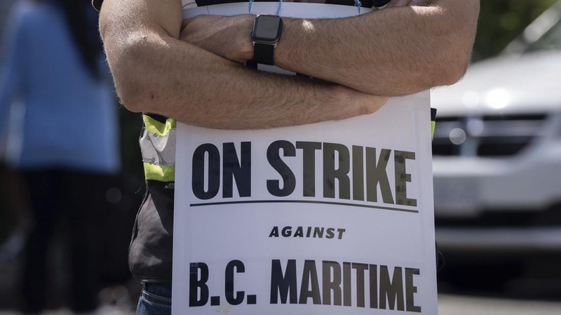 International Longshore and Warehouse Union workers picket outside of the BC Maritime Employers Association Dispatch Center after a 72 hour strike notice and no agreement made on the bargaining table in Vancouver, on Saturday, July 1, 2023. (Ethan Cairns /The Canadian Press via AP)