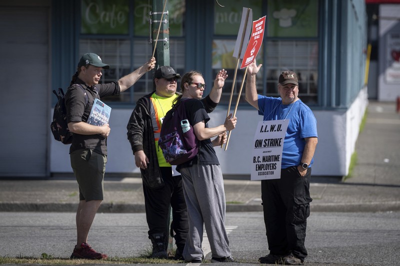 Canada Vancouver Port Strike International Longshore and Warehouse Union workers picket outside of the BC Maritime Employers Association Dispatch Center after a 72 hour strike notice and no agreement made on the bargaining table in Vancouver, on Saturday, July 1, 2023. (Ethan Cairns /The Canadian Press via AP)