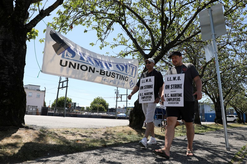 Canada Vancouver Port Strike International Longshore and Warehouse Union workers picket outside of the BC Maritime Employers Association Dispatch Center after a 72 hour strike notice and no agreement made on the bargaining table in Vancouver, on Saturday, July 1, 2023. (Ethan Cairns /The Canadian Press via AP)