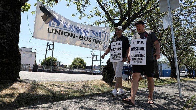 International Longshore and Warehouse Union workers picket outside of the BC Maritime Employers Association Dispatch Center after a 72 hour strike notice and no agreement made on the bargaining table in Vancouver, on Saturday, July 1, 2023. (Ethan Cairns /The Canadian Press via AP)
