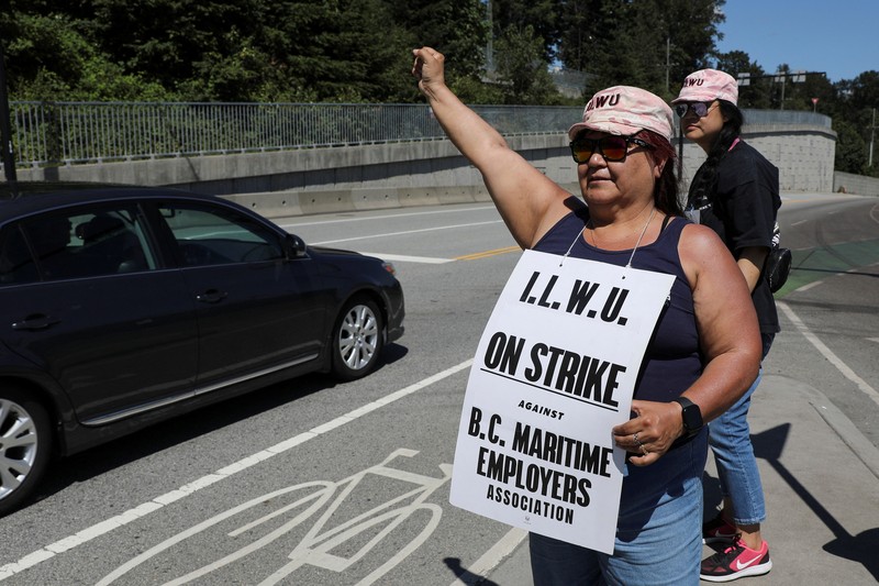 Canada Vancouver Port Strike International Longshore and Warehouse Union workers picket outside of the BC Maritime Employers Association Dispatch Center after a 72 hour strike notice and no agreement made on the bargaining table in Vancouver, on Saturday, July 1, 2023. (Ethan Cairns /The Canadian Press via AP)