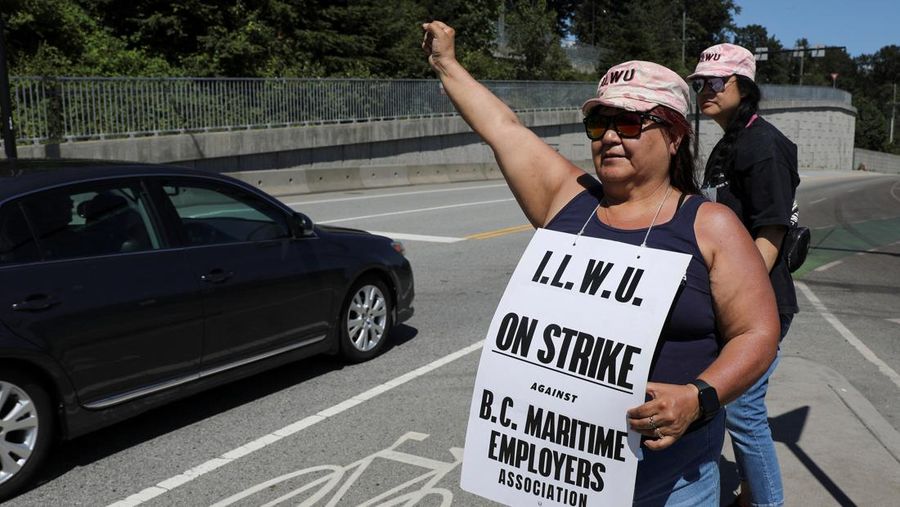 International Longshore and Warehouse Union workers picket outside of the BC Maritime Employers Association Dispatch Center after a 72 hour strike notice and no agreement made on the bargaining table in Vancouver, on Saturday, July 1, 2023. (Ethan Cairns /The Canadian Press via AP)