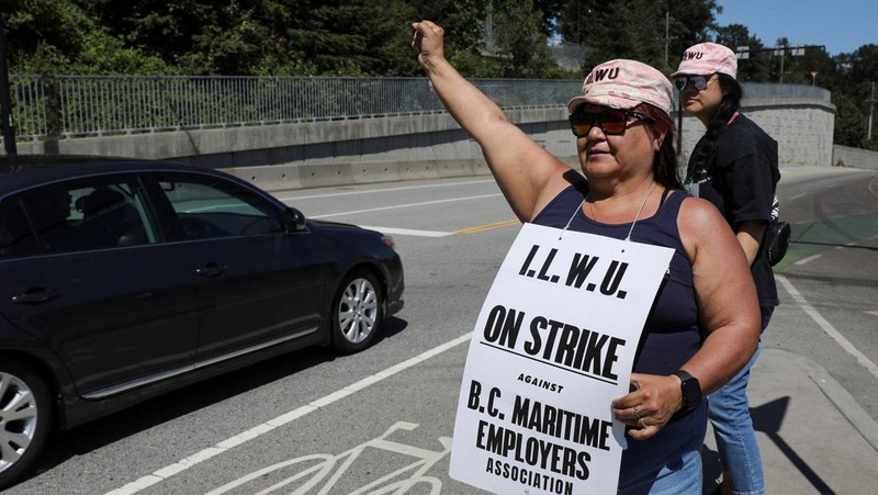 International Longshore and Warehouse Union workers picket outside of the BC Maritime Employers Association Dispatch Center after a 72 hour strike notice and no agreement made on the bargaining table in Vancouver, on Saturday, July 1, 2023. (Ethan Cairns /The Canadian Press via AP)