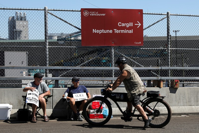 International Longshore and Warehouse Union workers picket outside of the BC Maritime Employers Association Dispatch Center after a 72 hour strike notice and no agreement made on the bargaining table in Vancouver, on Saturday, July 1, 2023. (Ethan Cairns /The Canadian Press via AP)