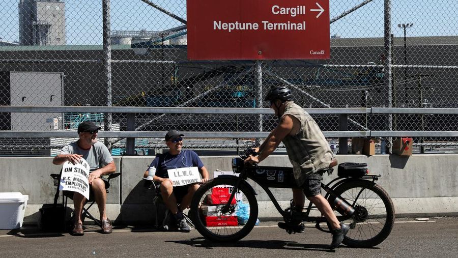 International Longshore and Warehouse Union workers picket outside of the BC Maritime Employers Association Dispatch Center after a 72 hour strike notice and no agreement made on the bargaining table in Vancouver, on Saturday, July 1, 2023. (Ethan Cairns /The Canadian Press via AP)
