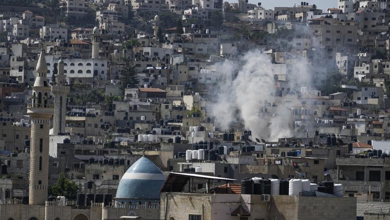 Asap mengepul selama serangan militer Israel ke kubu militan Jenin di Tepi Barat yang diduduki, Senin, 3 Juli 2023. Pejabat kesehatan Palestina mengatakan setidaknya tiga warga Palestina tewas dalam serangan itu. (AP Photo/Majdi Mohammed)