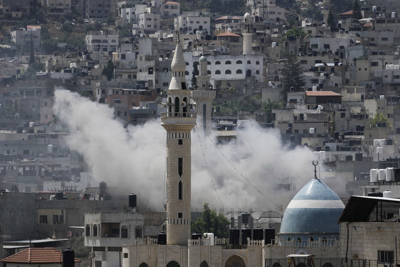 Asap mengepul selama serangan militer Israel ke kubu militan Jenin di Tepi Barat yang diduduki, Senin, 3 Juli 2023. Pejabat kesehatan Palestina mengatakan setidaknya tiga warga Palestina tewas dalam serangan itu. Asap mengepul selama serangan militer Israel ke kubu militan Jenin di Tepi Barat yang diduduki, Senin, 3 Juli 2023. Pejabat kesehatan Palestina mengatakan setidaknya tiga warga Palestina tewas dalam serangan itu. (AP Photo/Majdi Mohammed)