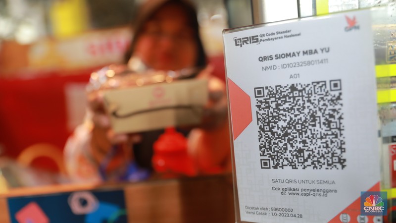 Pembeli melakukan transkasi pembayaran qris di Pasar Santa, Jakarta, Senin, (3/7). Pembeli melakukan transkasi pembayaran qris di Pasar Santa, Jakarta, Senin, (3/7). (CNBC Indonesia/Muhammad Sabki)