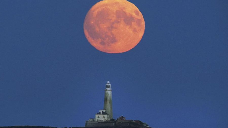 Supermoon 'Full Buck' terbit di atas Mercusuar St Mary di Whitley Bay, di pantai Timur Laut Inggris pada Minggu malam, 2 Juli 2023. Supermoon Juli akan mencapai titik terdekatnya dengan Bumi pada 224.895 mil (361.934 km) - sekitar 13.959 mil (22.466 km) lebih dekat dari biasanya. Tampaknya 5,8 persen lebih besar dan 12,8 persen lebih terang dari bulan purnama biasa. (Owen Humphreys/PA via AP)