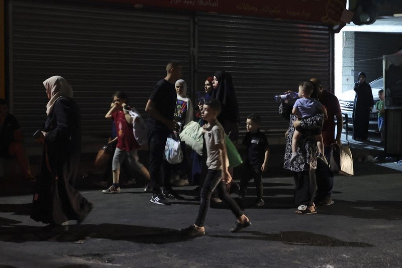 Warga Palestina yang tinggal di kamp pengungsian Jenin mulai meninggalkan rumah mereka, Senin malam (3/7/2023) waktu setempat. (AFP/JAAFAR ASHTIYEH) Warga Palestina yang tinggal di kamp pengungsian Jenin mulai meninggalkan rumah mereka, Senin malam (3/7/2023) waktu setempat. (AFP/JAAFAR ASHTIYEH)