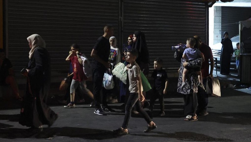 Warga Palestina yang tinggal di kamp pengungsian Jenin mulai meninggalkan rumah mereka, Senin malam (3/7/2023) waktu setempat. (AFP/JAAFAR ASHTIYEH)