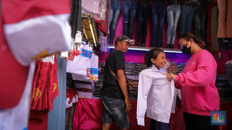 Sejumlah pembeli mencoba seragam dan atribut sekolah di kawasan Jatinegara, Jakarta Timur, Rabu (5/7/2023). (CNBC Indonesia/Faisal Rahman)