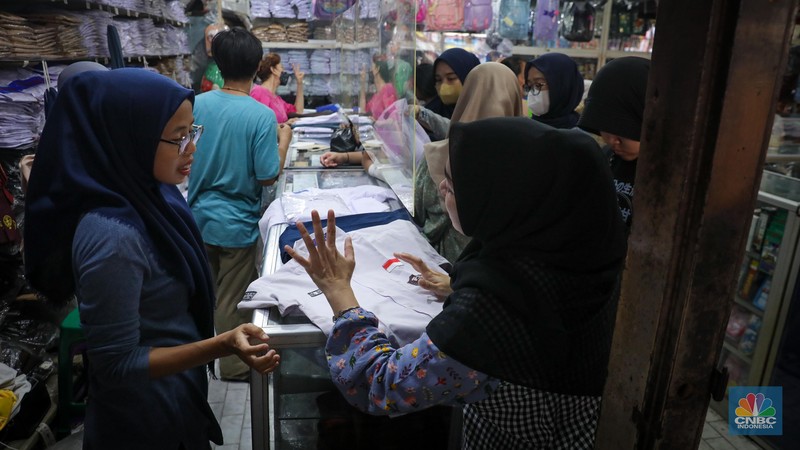 Sejumlah pembeli mencoba seragam dan atribut sekolah di kawasan Jatinegara, Jakarta Timur, Rabu (5/7/2023). (CNBC Indonesia/Faisal Rahman)