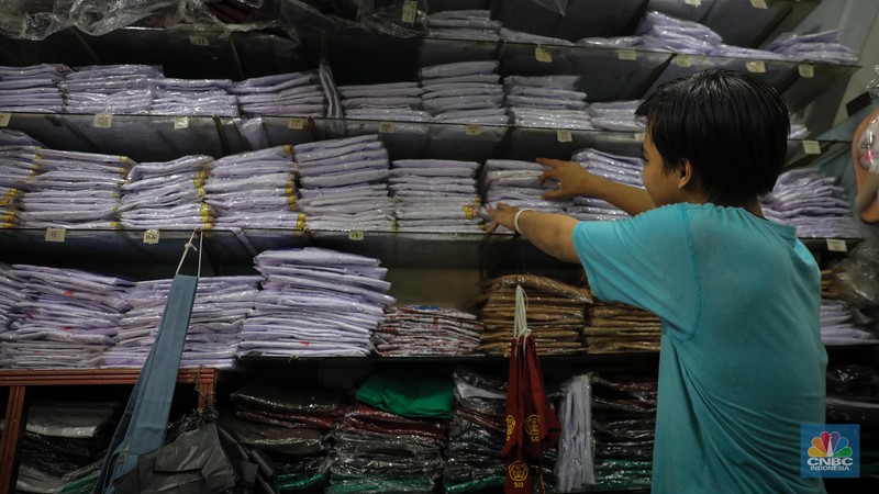 Sejumlah pembeli mencoba seragam dan atribut sekolah di kawasan Jatinegara, Jakarta Timur, Rabu (5/7/2023). (CNBC Indonesia/Faisal Rahman)