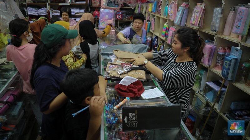 Sejumlah pembeli mencoba seragam dan atribut sekolah di kawasan Jatinegara, Jakarta Timur, Rabu (5/7/2023). (CNBC Indonesia/Faisal Rahman)