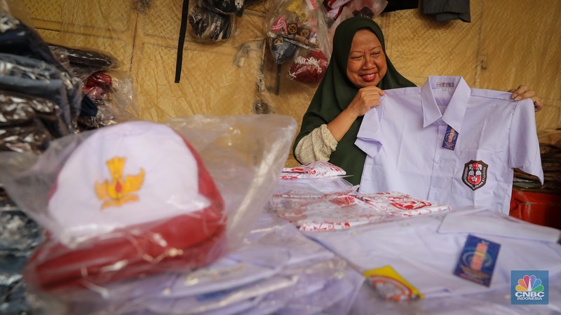 Sejumlah pembeli mencoba seragam dan atribut sekolah di kawasan Jatinegara, Jakarta Timur, Rabu (5/7/2023). (CNBC Indonesia/Faisal Rahman)