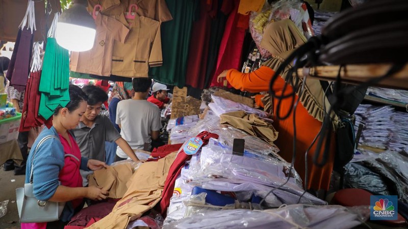 Sejumlah pembeli mencoba seragam dan atribut sekolah di kawasan Jatinegara, Jakarta Timur, Rabu (5/7/2023). (CNBC Indonesia/Faisal Rahman)
